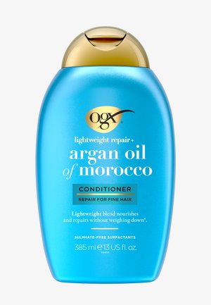 OGX letvægtsreparationsbalsam i en turkis plastflaske med en guldlåg. Teksten fremhæver arganolie og reparation til fint hår. 385 ml.