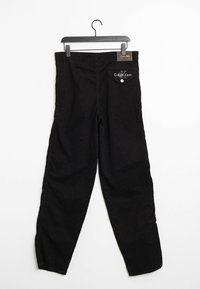 Pantalones negros de tela, con un diseño de pierna recta, un bolsillo trasero con botón y un logo de Calvin Klein en la cinturilla.