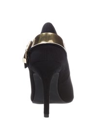 Scarpa nera con tacco alto, punta affusolata e sottile tacco a stiletto, con una brillante fascia dorata sul retro. Finitura in tessuto strutturato.