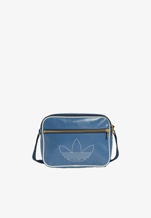 Niebieska prostokątna torba na ramię z białym obszyciem, przednią kieszenią na zamek, regulowanym paskiem i dużym logo Adidas trefoil w białym przeszyciu.