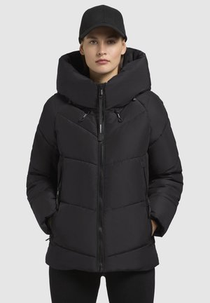 Black puffer jacket with a high collar and large hood. Features quilted design, zippered pockets, and a central zipper closure.