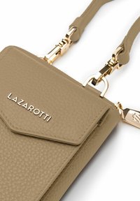 Bolso de mano de cuero texturizado beige con cierre de solapa, herrajes dorados y el nombre de la marca "LAZAROTTI" grabado en la parte frontal.