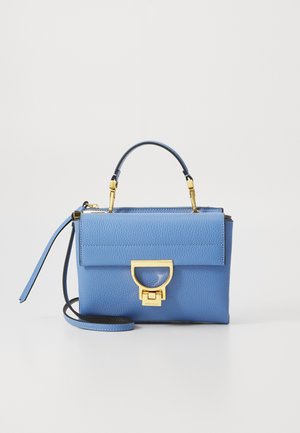 Blue leather handbag with a structured shape, gold hardware, a top handle, and a detachable strap. Features a flap closure with a distinctive clasp.