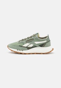 Light green sneaker featuring a suede and mesh upper, white accents, a thick white sole, and a rubberized brown outsole.