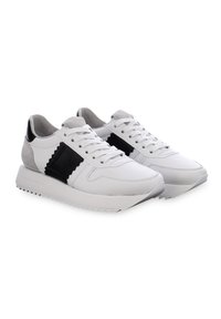 Weiße Sneaker mit einem schwarz-grauen Design, gefertigt aus glattem Leder und Wildleder, mit einer strukturierten Sohle und Zickzack-Akzenten.