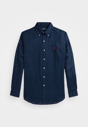 Camicia button-up blu navy a maniche lunghe realizzata in lino. Presenta un colletto, bottoni bianchi e un piccolo logo rosso sul petto.