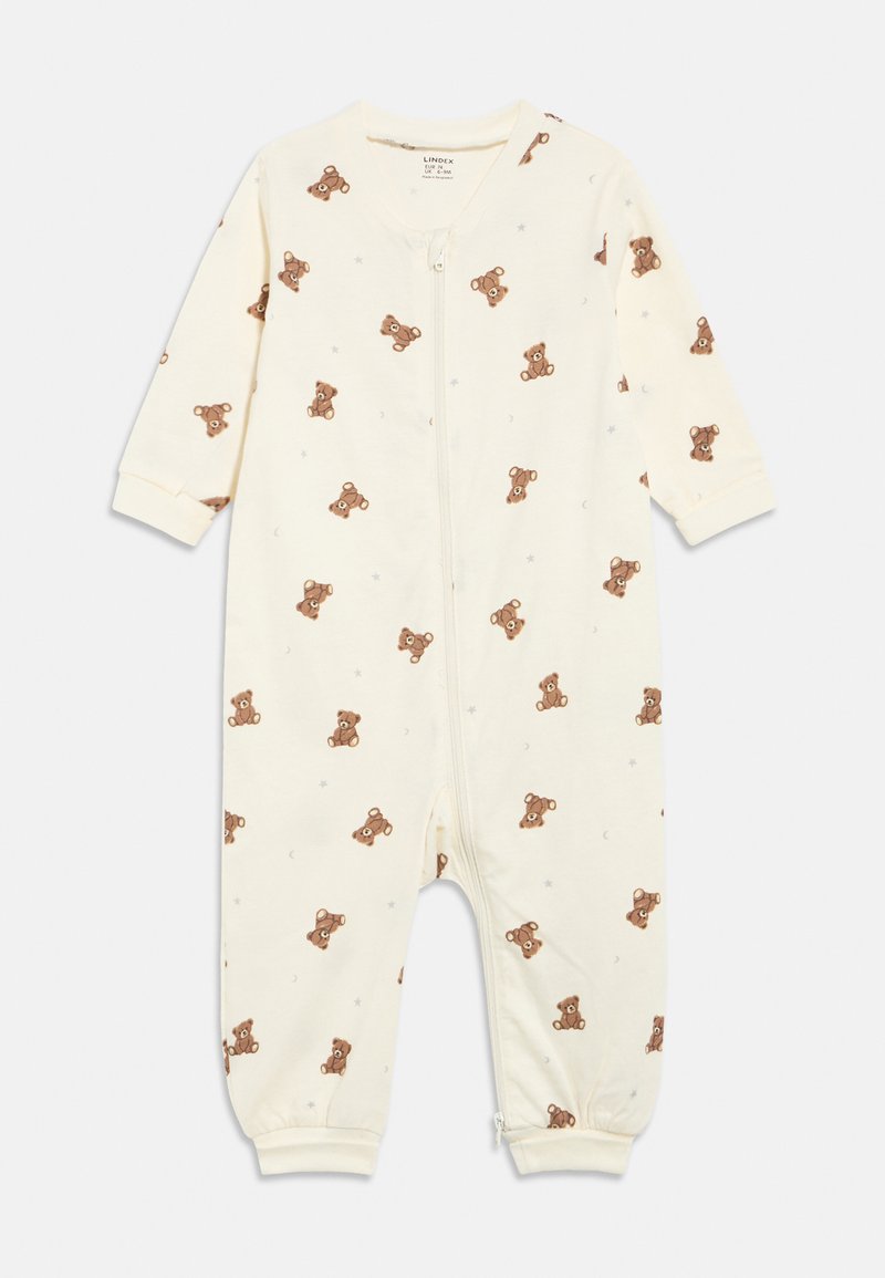 Krēmkrāsas zīdaiņa kombinezons ar brūna tēja lāča, zvaigznes un pusmēness rakstu, garām piedurknēm un rāvējslēdzēju priekšpusē.