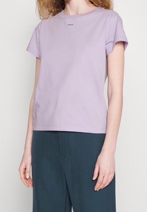 Liliowy bawełniany t-shirt z krótkimi rękawami i okrągłym dekoltem. Małe czarne logo "PINKO" nad klatką piersiową. Prosty, luźny fason.