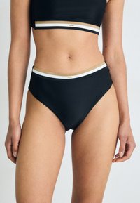 Črn bikini set z krojenim topom in visokim pasom. Akcenti belih in zlatih črt ob pasu. Gladko, raztegljivo blago.