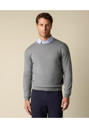 Maglione grigio lavorato a maglia con collo rotondo, polsini e orlo a costine. Indossato sopra una camicia a colletto azzurro chiaro. Texture liscia, design informale.