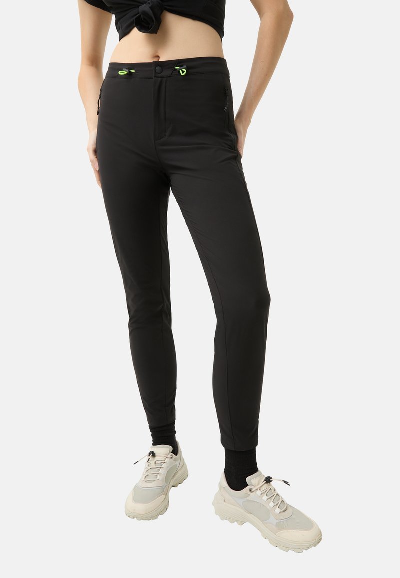 Black stretch pants with a slim fit, featuring two zippered pockets and neon green drawstrings at the waistband. Smooth texture.