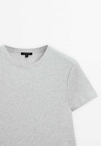 Lys grå kortærmet T-shirt lavet af ribbet materiale med rund halsudskæring. Vist fladt mod en hvid baggrund.