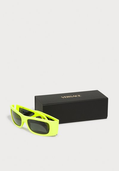 Neoonkollased päikeseprillid ristkülikukujulise raami, tumedate läätsede ja mattviimistlusega. Saadaval kahjustamata mustas Versace kaubamärgiga karbis.