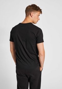 Black short-sleeve t-shirt, made of cotton, featuring a round neck and a smooth texture, displayed from a rear view.