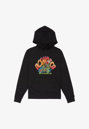 Hoodie noire avec logo graphique coloré, short en jean clair et baskets noires avec accents blancs et marque rouge. Chaussettes blanches visibles.