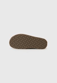 Shoe sole with a wavy pattern, made of rubber, featuring a textured brown surface and rounded edges for traction and durability.