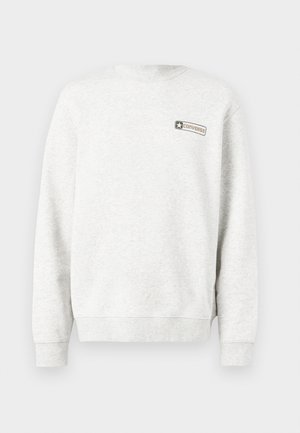 Helehall hall, pika varrukaga dressipluus pisikese "Converse" logoga vasakul ülemisel rinnal, millel on soonikuga varrukaservad ja alumine serv.