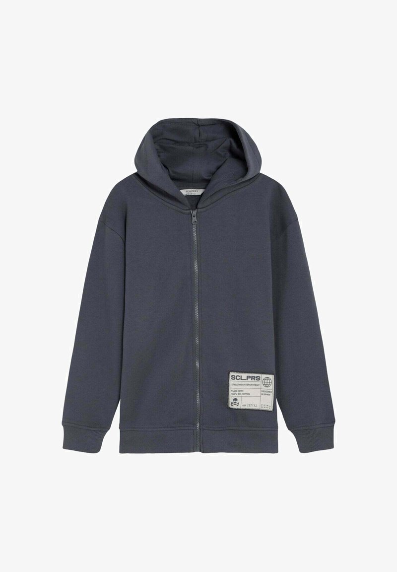 Sweat à capuche zippé intégral gris foncé avec étiquette patch sur le devant, manches longues, poignets côtelés et capuche attachée.