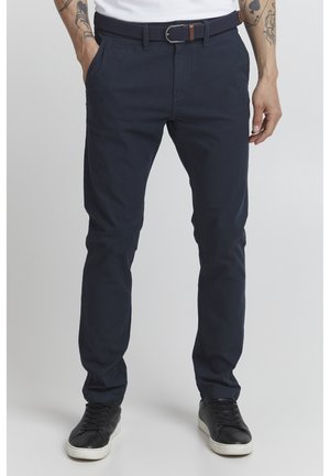 Navy blue cotton chinos with a slim fit, featuring belt loops, side pockets, and a woven belt with a silver buckle. Smooth texture.