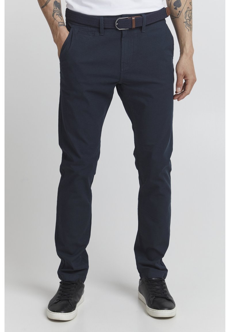 Mörkblå bomullschinos med slim fit, med bälteshällor, sidofickor och ett vävt bälte med silverspänne. Slät textur.