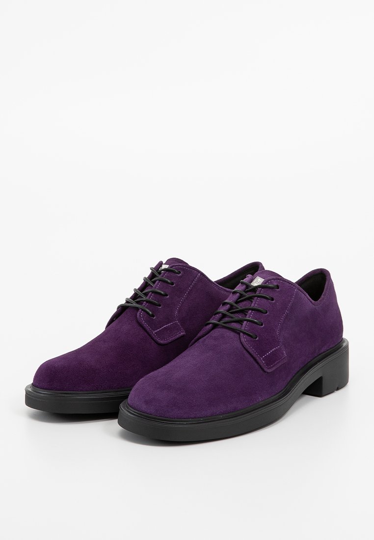 Chaussures en daim violettes à lacets, avec un bout arrondi et une semelle en caoutchouc noire, présentant des lacets assortis et une texture lisse.