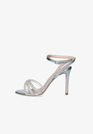 Sandal con tacco alto argento con una finitura metallica elegante, design a strisce incrociate con strass decorativi e una sottile cinturini alla caviglia.