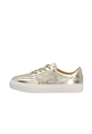 Lage sneaker met metallic gouden leren bovenwerk, beige veters en dikke witte rubberen zool, zijaanzicht op witte achtergrond.