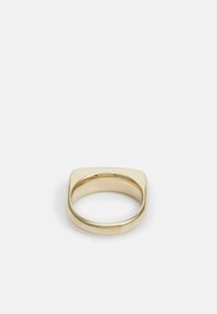 Goldener Metallring mit quadratischer Oberseite und rundem Umfang, der eine glatte, glänzende Oberfläche aufweist. Das Design ist minimalistisch und modern.