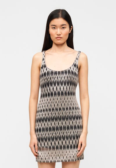 Robe en tricot à silhouette ajustée, présentant un motif en losanges aux tons noirs et argentés, avec de larges bretelles. Texture lisse.