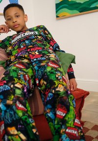 Minecraft-themed pajama set with a dark background, featuring colorful character graphics, long sleeves, and elastic waistband for comfort.