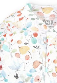 Weißer Stoff mit einem floralen Muster, das bunte Blätter und Blumen in Blau-, Orange- und Grüntönen zeigt; Knopfverschluss am Ausschnitt.