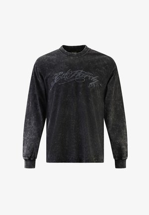 Černé tričko s dlouhým rukávem a vybledlou texturou, s šedým písmem na přední straně, žebrovanými manžetami a kulatým výstřihem.