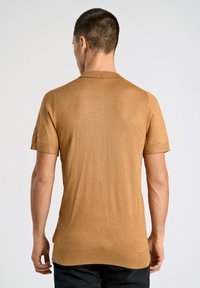 Maglione a maniche corte in un colore marrone chiaro, realizzato in materiale a maglia testurizzato, con scollatura rotonda e orlo dritto.