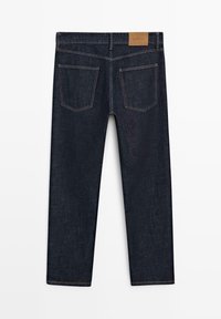 Dark blue straight-leg jeans shown from the back with two back pockets and a brown leather brand patch on the waistband.