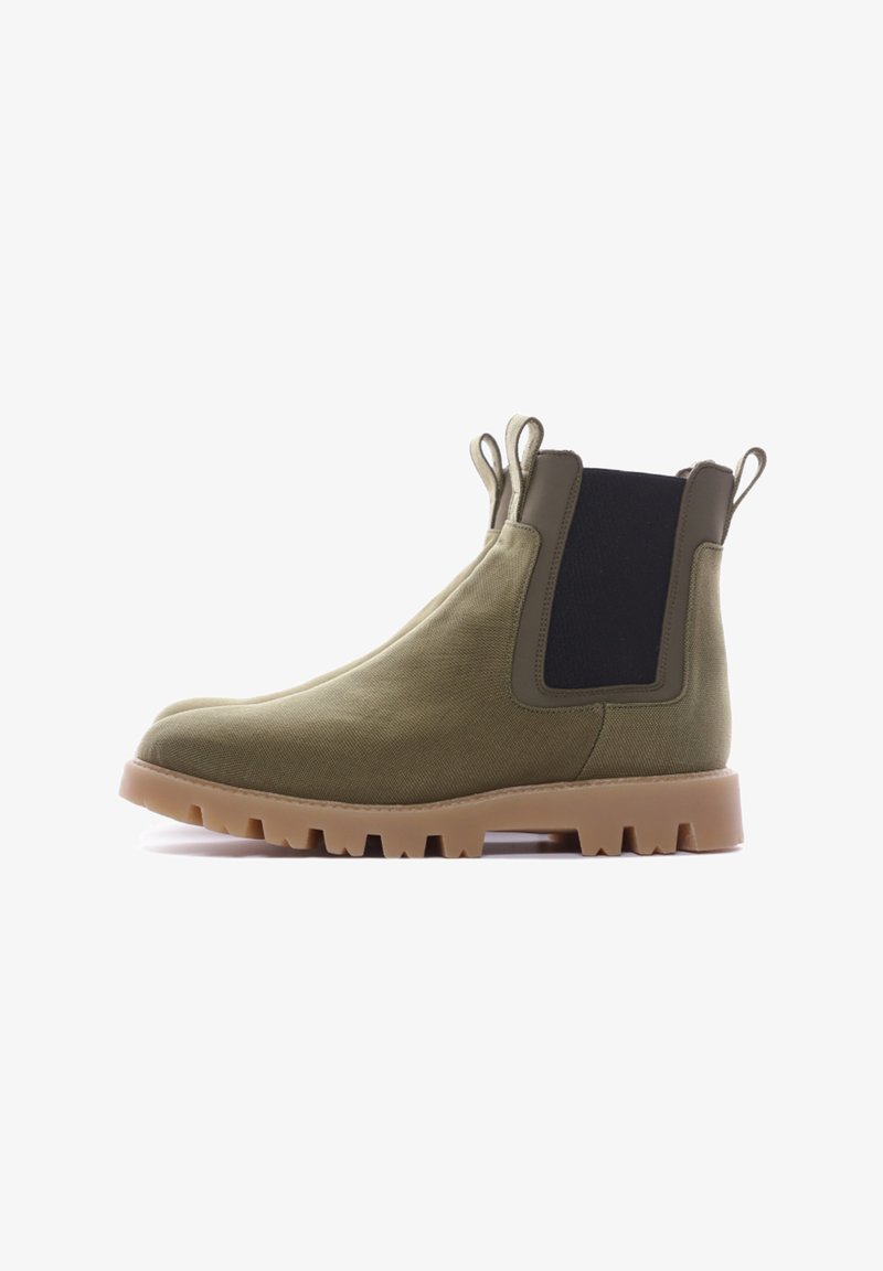 Bottines en toile vert olive avec des panneaux latéraux élastiques noirs, des languettes de tirage et une semelle robuste marron clair. Bout arrondi et finition texturée.