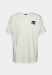 Krátký rukáv, tričko s kulatým výstřihem v barvě off-white z bavlny. Na levé hrudi je černé oválné logo. Uvolněný střih s rovým lemem.