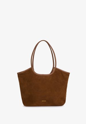 Sac fourre-tout en suède marron avec des poignées doubles, bordures en cuir contrastant, ouverture sur le dessus et un discret branding doré à l'avant. Forme de sac ajustable.