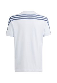 Biała koszulka z krótkim rękawem z trzema niebieskimi paskami na górnej części pleców i rękawach, przedstawiona z tyłu na białym tle.