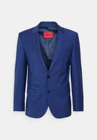 Marineblauwe op maat gemaakte blazer met twee knopen, revers-kraag en twee voorzakken. Gevoerde binnenkant met een rode merketiket.