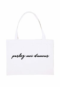 Borsa tote bianca in tela con due manici robusti e testo in corsivo nero "parlez moi d'amour" sul davanti.