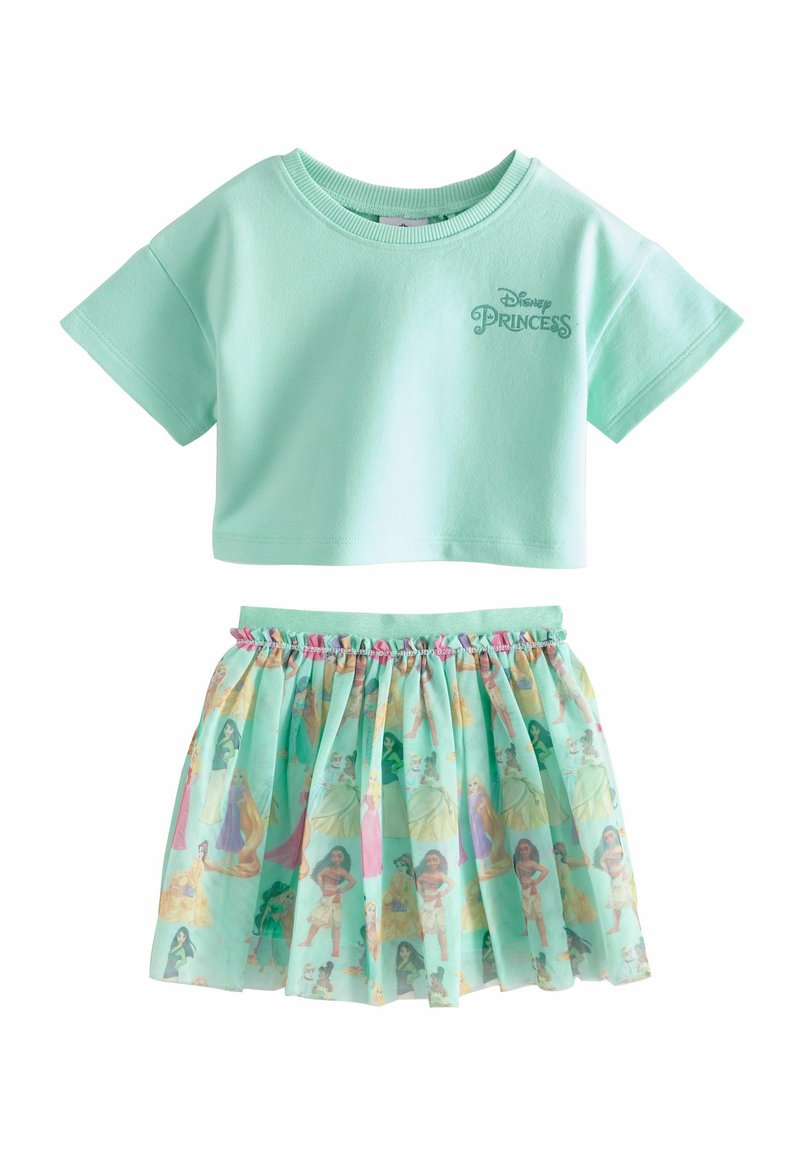 Mündroheline lühikeste varrukatega crop top, millel on kirjas "Disney printsess", kombineeritud kihilise, läbipaistva seelikuga, millel on värvilised printsessi tegelaskujude trükised.