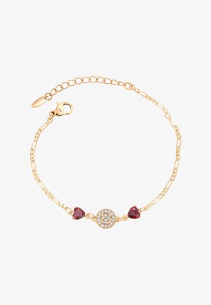 Aranyszínű karkötő, amelyen egy kör alakú medál található, tiszta rhinestone-okkal díszítve, két piros szív alakú kővel szegélyezve, láncszemes dizájnban.