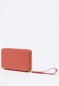 Cartera de cuero color rosa con acabado texturizado, cierre de cremallera, herrajes en tono dorado y una correa de muñeca a juego. Forma compacta y rectangular.