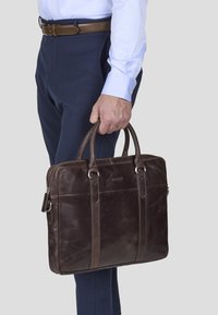 Brunlæder laptoptaske med dobbelte håndtag og lynlåslukning, som har en glat overflade og subtile sy-detaljer.