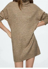 Robe-pull oversize marron clair avec col roulé, poignets et ourlet côtelés. Texture en maille douce, coupe décontractée et épaules tombantes.