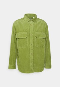 Camicia in corduroy verde con maniche lunghe, chiusura a bottoni sul davanti, due tasche sul petto e colletto classico. Tessuto texturizzato con righe verticali.