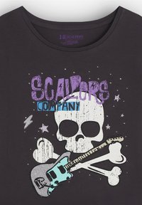Camiseta de algodón negra con un cráneo blanco, huesos cruzados y un gráfico de guitarra en teal y plateado con acentos en texto púrpura y azul.
