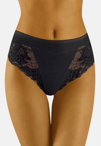 Culottes noires taille haute avec un devant en tissu lisse et des côtés en dentelle transparente ornés d'un motif floral et de bords festonnés.