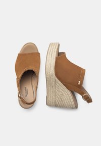 Sandales à talons compensés en suède marron avec une ouverture ronde, un talon enveloppé de jute et une sangle de cheville réglable. Comprend un logo discret sur le côté.