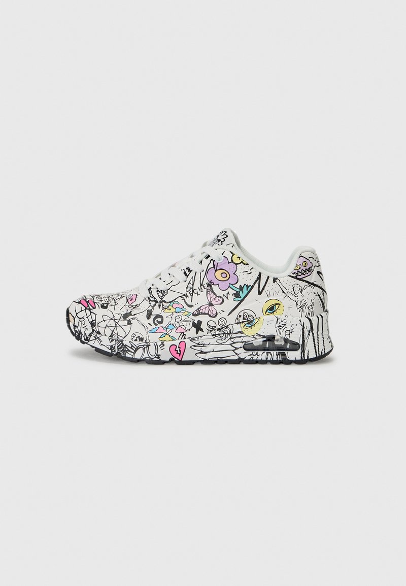Witte sneaker met zwarte accenten en meerkleurige grafische ontwerpen, met bloemen- en cartoon-elementen, zichtbare veters en een gestructureerde zool.